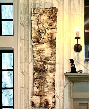 Wood art piece on patterned wall.