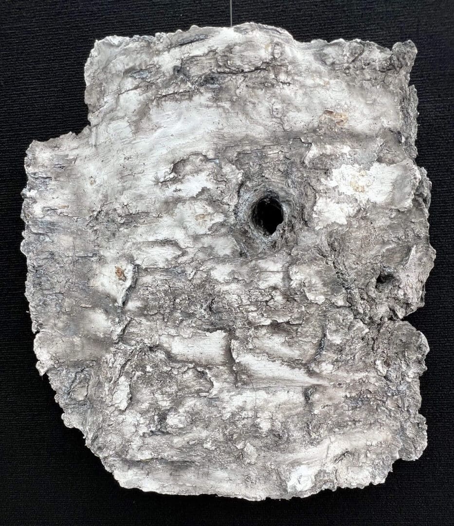 Ancient clay tablet with cuneiform script and a hole in the center.