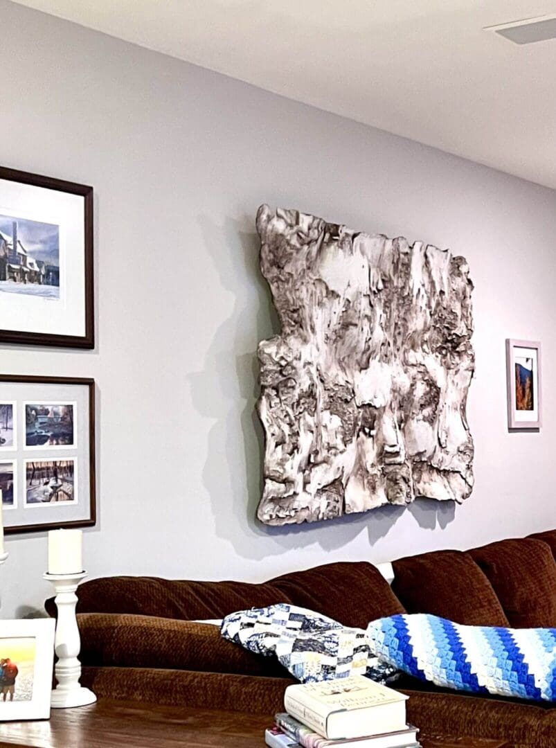 Abstract textured wall art above a brown sofa in a modern living room.