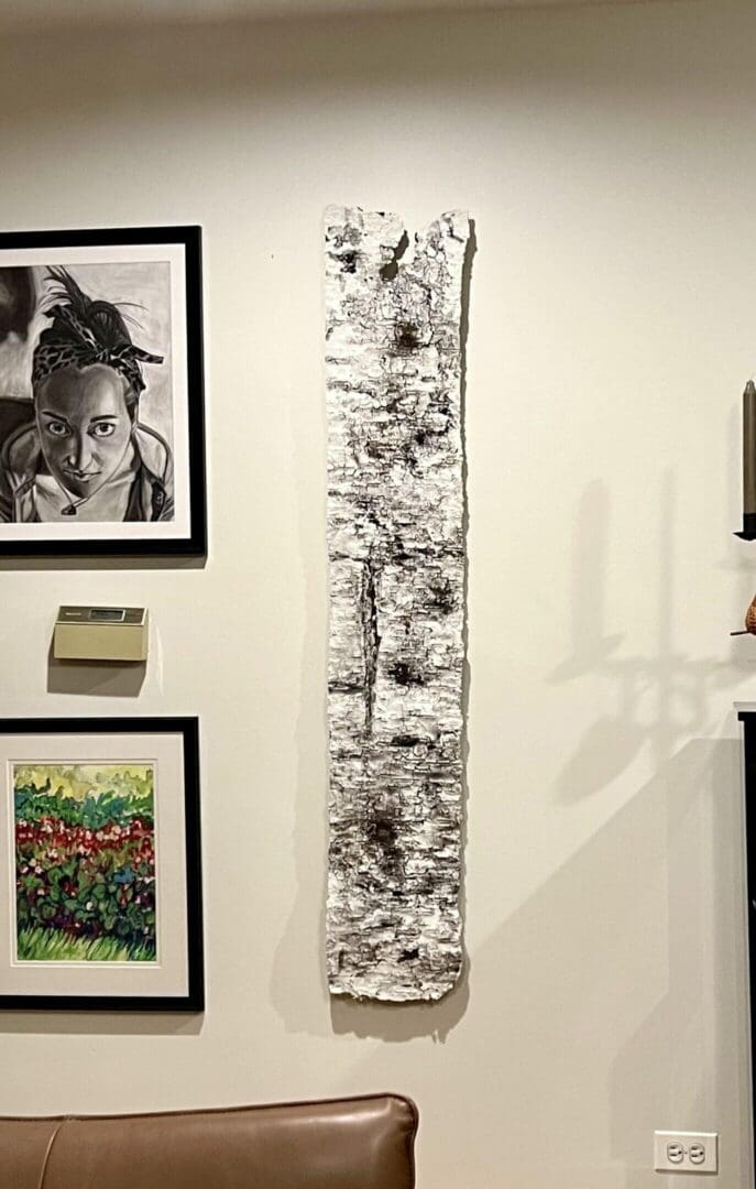 Gallery wall with diverse framed artworks and shadow play.
