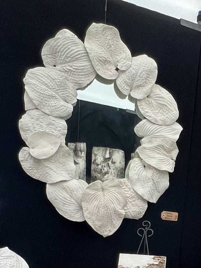 Decorative mirror framed with textured, petal-like elements.
