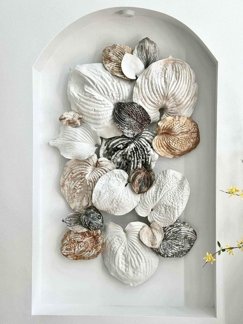 Decorative wall art featuring textured, leaf-like shapes in neutral tones.