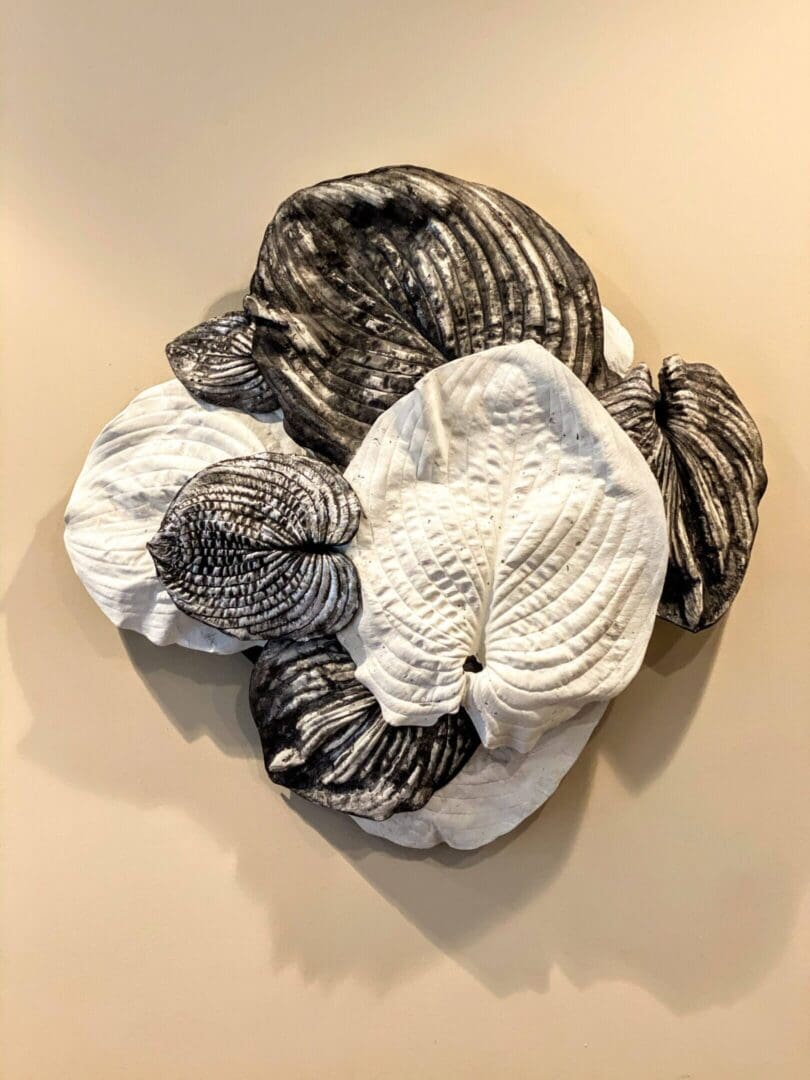 Abstract black and white textile wall art with intricate patterns.