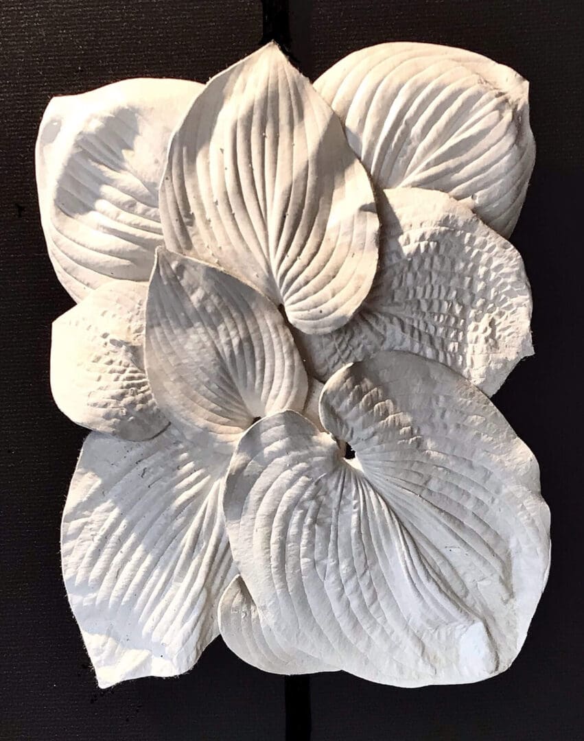 White textured floral sculpture with detailed petals and leaves.