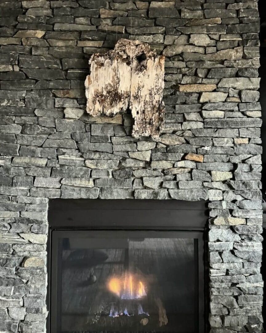 Modern stone fireplace with a cozy fire burning inside.