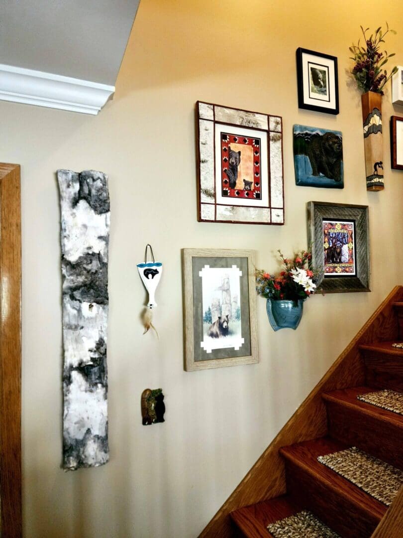 A wall gallery beside stairs with framed art and decor.