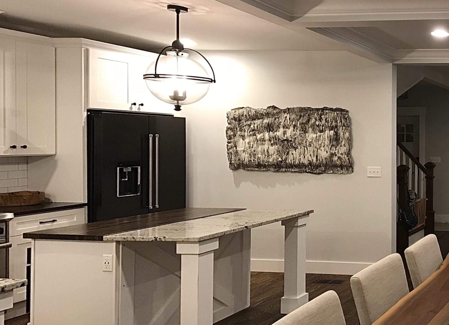 Modern kitchen with a black refrigerator and island seating.